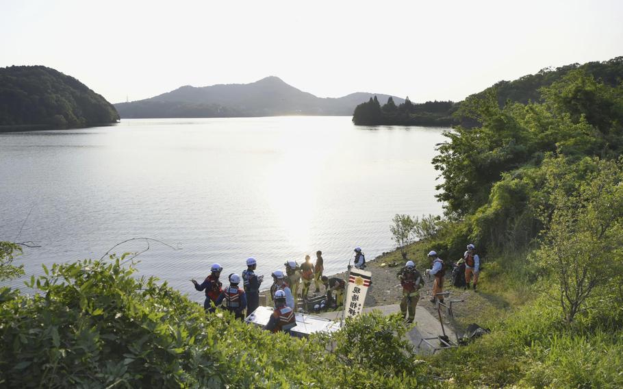 Firefighters gather for a search operation as a Japanese air force plane crashed after taking off for a training flight, at a pond in Inuyama, Japan, Wednesday, May 14, 2025.
