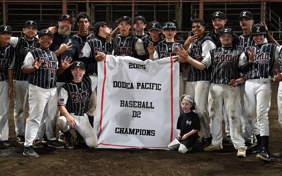 Zama's players gather round the championship banner.