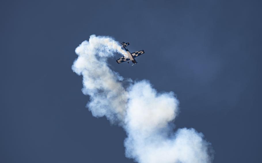 An aircraft leaves behind a cloud of smoke in the air