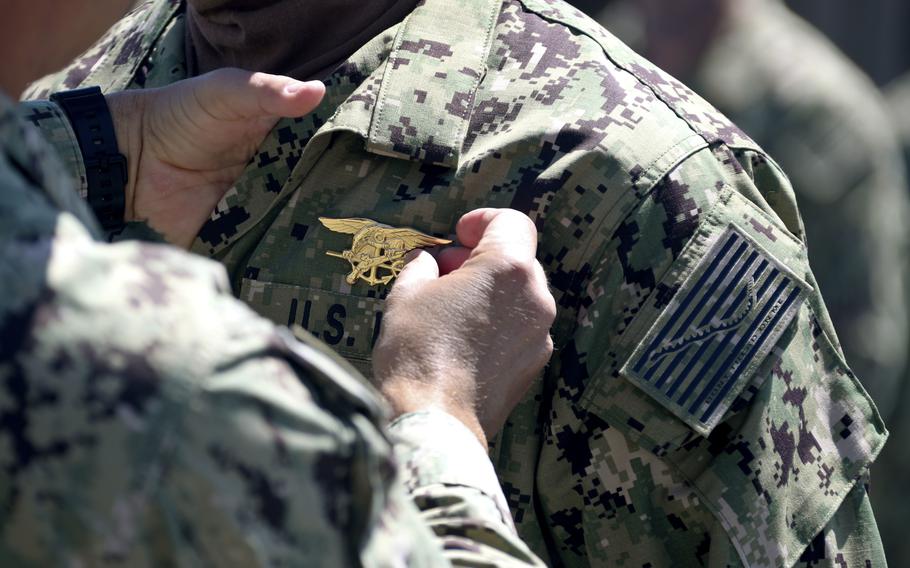 Commanding officer at the Naval Special Warfare Basic Training Command places a Special Warfare pin, known as a “Trident,” on a member of SEAL Qualification Training Class 336 during their graduation ceremony at NSW Center in Coronado, Calif., on April 15, 2020. Twenty-six Navy SEALs and nine other special operations sailors asked a federal court to shield them from the Pentagon’s coronavirus vaccine mandate, claiming in a lawsuit Tuesday that it unconstitutionally infringes on their religious rights.