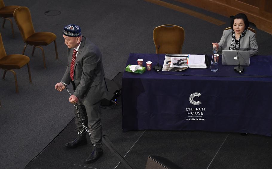 Witness Omir Bekali demonstrates to the Panel of the independent Uyghur Tribunal during the first session of the hearings in London on June 4, 2021, how he says he was chained for seven months.