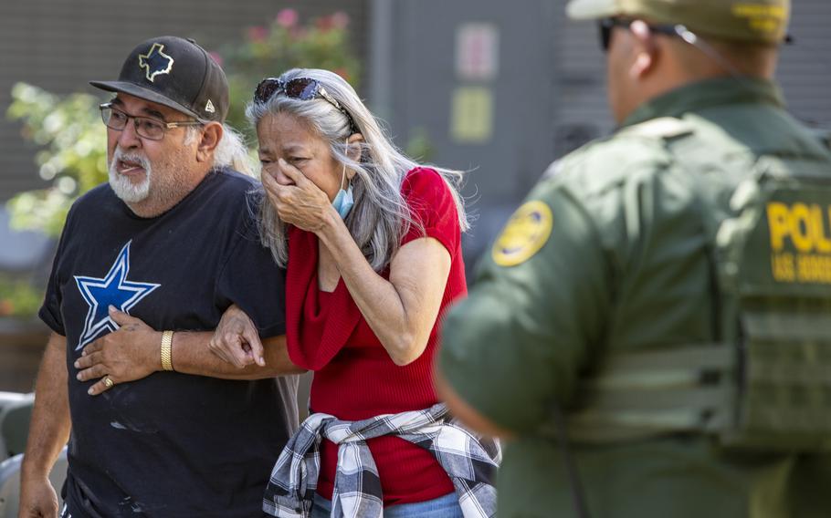 A woman cries Tuesday, May 24, 2022, as she leaves the Uvalde Civic Center, in Uvalde, Texas. At least 14 students and one teacher were killed when a gunman opened fire at Robb Elementary School in Uvalde, according to Texas Gov. Gregg Abbott.