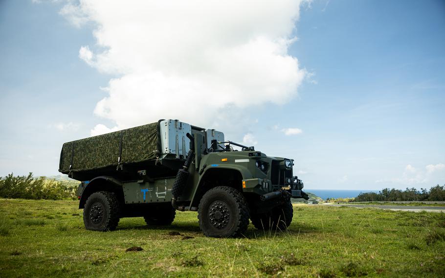 A military vehicle is parked on a grassy field.