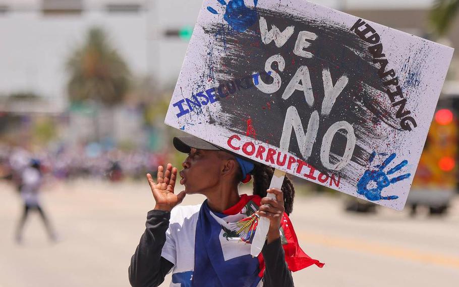 A protester joins Haitians across the United States and the world while marching towards Miami’s City Hall on July 9, 2023, to demand relief for Haiti. 