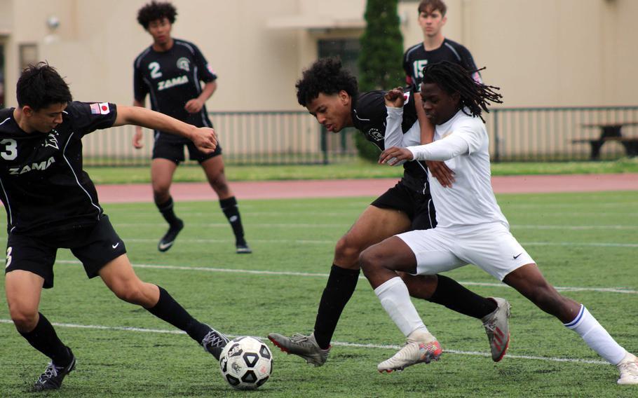 Zama's Roman Romero and Chris Jones battle Yokota's Kysiem Banks for the ball during Wednesday's Boys Division II soccer match. The Panthers won 2-1 in extra time.