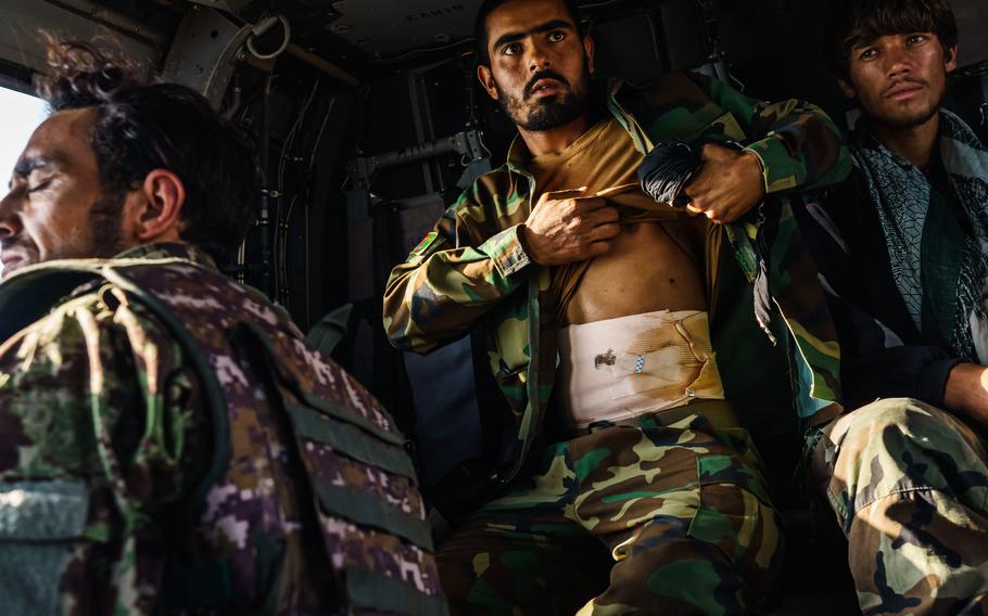 Soldiers, some wounded by Taliban gunfire, leave the Shah Wali Kot outpost in Kandahar, Afghanistan, aboard an UH-60 Blackhawk. 