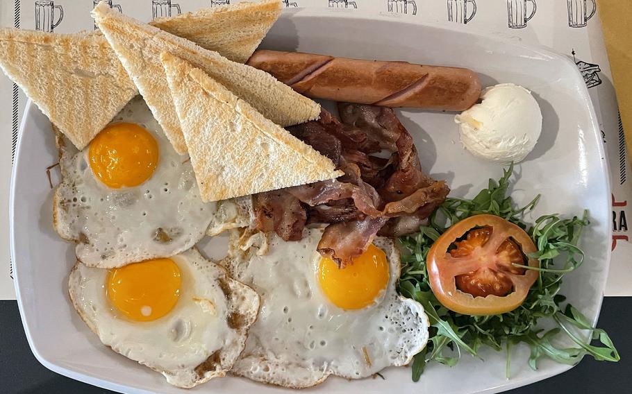 The American brunch at Mezza Libbra Burger and Bakery in Pordenone, Italy, on Feb. 2, 2024. The dish is served with three eggs, sausage, bacon, bread, butter and garnishes. 