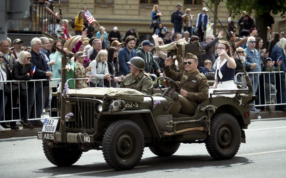 A jeep rolls past spectators.