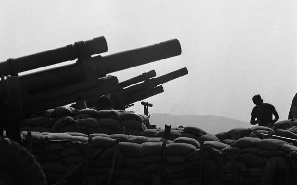 Hed: Cambodia out in the haze, 1968

Fre Support Base 25, South Vietnam, Mar. 11, 1968: 
A lone soldierfrom Company A, 3rd Battalion, 12th Infantry Division and 6th Battalion, 29th Artillery Division looks out through the haze into Cambodia, on a rare quiet morning. 
Overlooking the Cambodian border of Vietnam the base is one of many hill-top FSBs around Dak To. Together with the men from the surrounding FSBs, the men of FSB 25 cover the whole Dak To Bowl - the small, unnamed valley in which Dak To is located.
FSB 25 came under an intense mortar, rocket and ground attack January 31st in which nine men of 3/12 were wounded. 

Looking for Stars and Stripes’ coverage of the Vietnam War? Subscribe to Stars and Stripes’ historic newspaper archive! We have digitized our 1948-1999 European and Pacific editions, as well as several of our WWII editions and made them available online through https://starsandstripes.newspaperarchive.com/

META TAGS: Pacific; South Vietnam; war; combat; U.S. Army; Infantry; servicemen; soldier; combat; artillery; cannon; sandbags; Howitzer