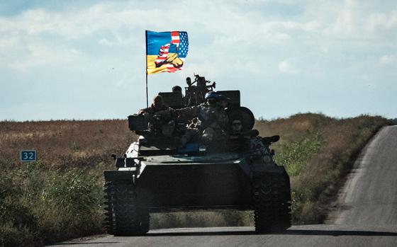 A Ukraine tank rides with a flag picturing Ukraine and US flags shaking hands in Novostepanivka, Kharkiv region, on Sept. 19, 2022, amid the Russian invasion of Ukraine. 