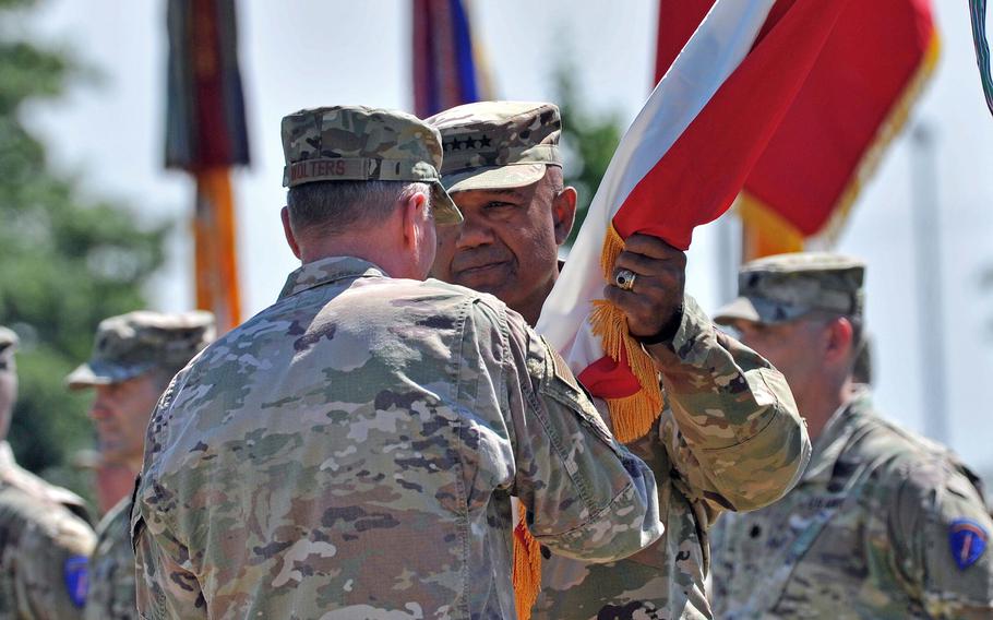 Incoming commander of U.S. Army Europe and Africa Gen. Darryl Williams takes the unit's colors from Gen. Tod Wolters in Wiesbaden, Germany, on June 28, 2022. Williams took command of the unit from Gen. Christopher Cavoli at the ceremony.