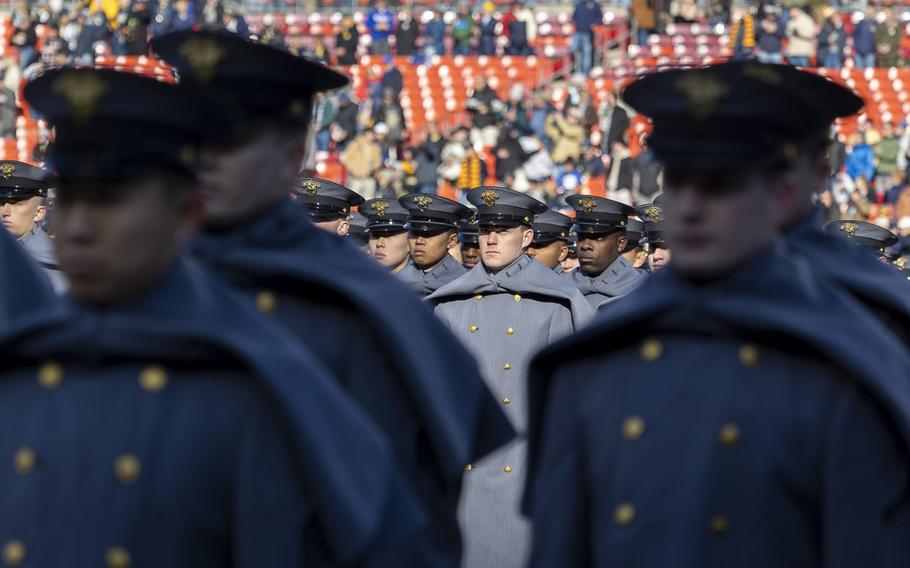 Cadets stand at attention on the field.