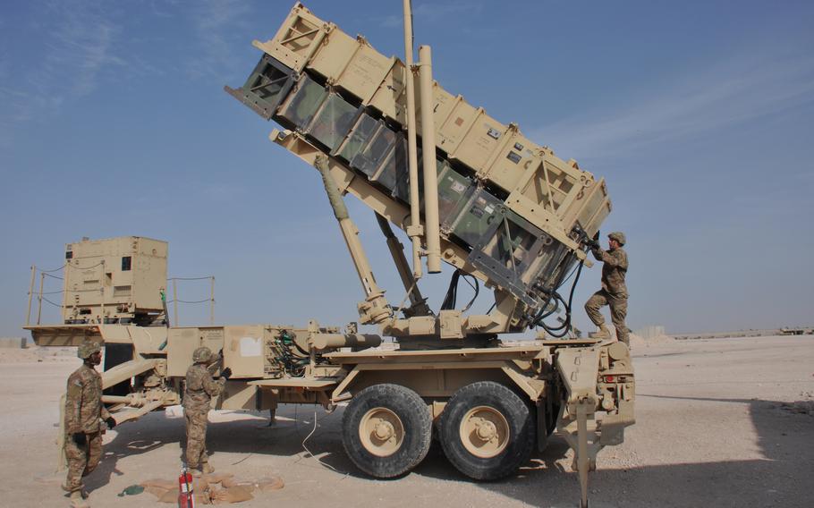 Soldiers stand next to a Patriot missile launcher 