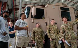 Aaron Jones, NFL Minnesota Vikings running back, and Elijah Higgins, NFL Arizona Cardinals tight end, both left, tour the 386th Expeditionary Civil Engineer Squadron fire station within the U.S. Central Command area of responsibility, April 2, 2025. The tour provided the players an opportunity to learn about the critical role of Air Force firefighters in supporting base operations and mission readiness. (U.S. Air Force photo by Senior Airman Mark Colmenares)