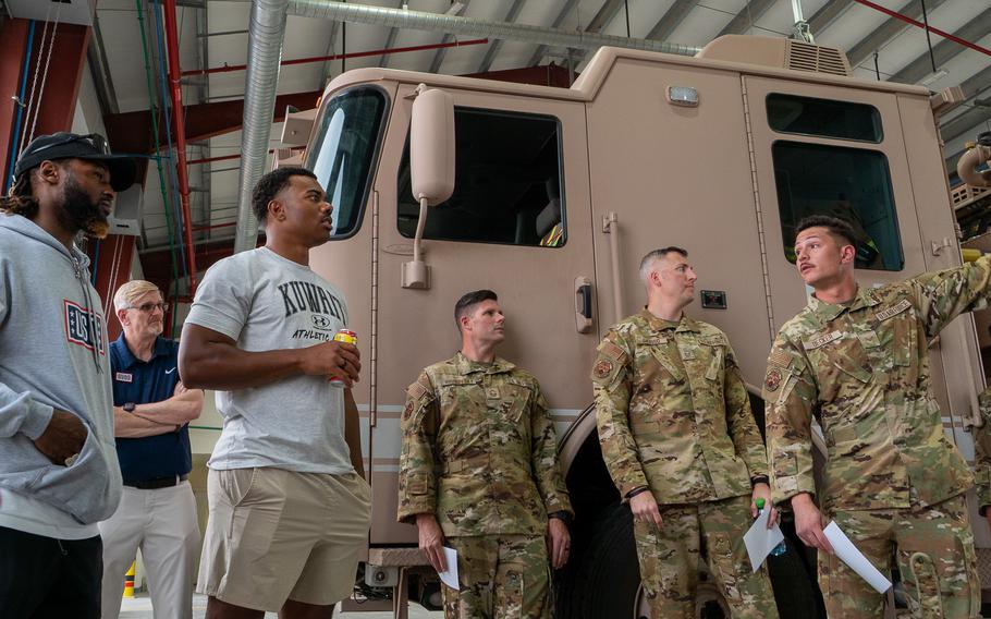 Two NFL players talk with airmen