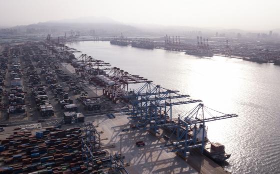 Cargo ships are moored under cranes as shipping containers stand at the Qingdao Qianwan Container Terminal in this aerial photograph taken in Qingdao, China, on Monday, May 7, 2018. China's overseas shipments exceeded estimates while imports surged, as the global economy continued to support demand. MUST CREDIT: Bloomberg photo by Qilai Shen