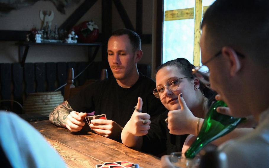 Sgt. Stuart McMullen, left, and Susanne Gerss enjoy a game of Uno at the Gerss’ home near Birkenfeld, Germany, Dec. 24, 2023.