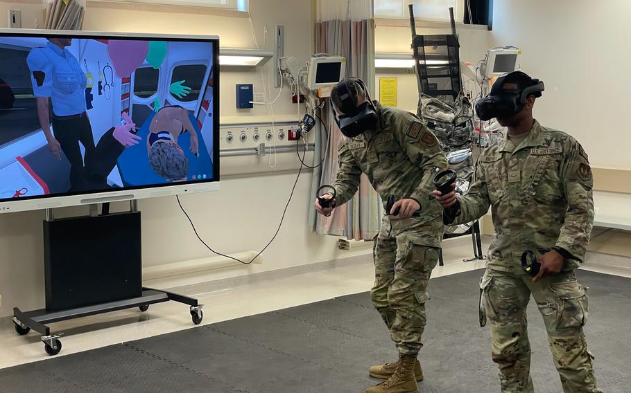 Airmen 1st Class Taylor Ziegler, left, and Tanner Patrick, both aerospace medical technicians with the 31st Medical Group at Aviano Air Base in Italy, simulate caring for a patient in an ambulance using virtual reality headsets on July 11, 2023. (Brian Erickson/Stars and Stripes)