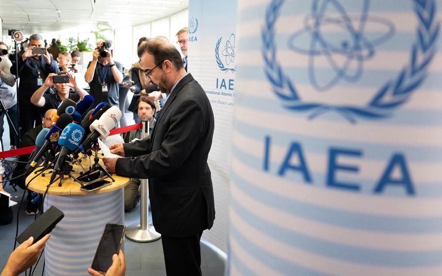 Najafi speaks to reporters, with the IAEA sign behind him.