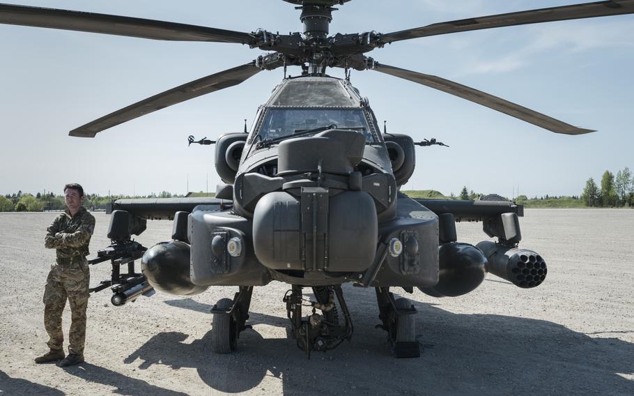 A British soldier stands by an Apache helicopter at Tapa Army Base in Estonia. The Baltics count on NATO for air defense. 