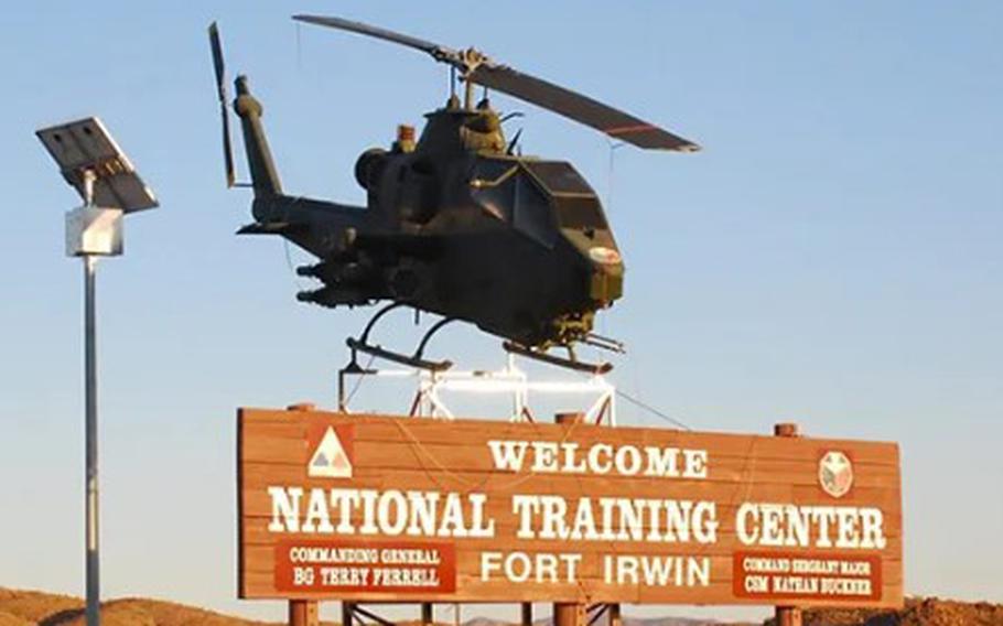 A helicopter displayed above an entrance sign at Fort Irwin National Training Center, Calif.