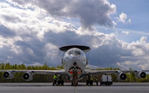 A flight crew guides an aircraft, seen from the front, on a runway.