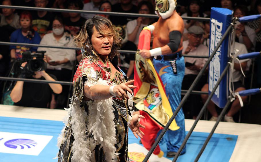 A festively dressed wrestler gestures to the crowd.