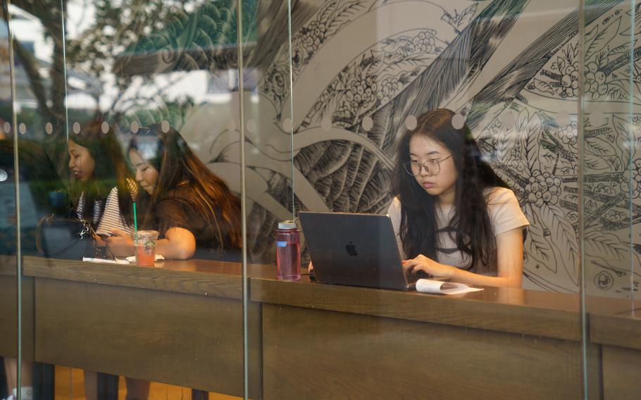A woman uses a laptop in a Singapore cafe.