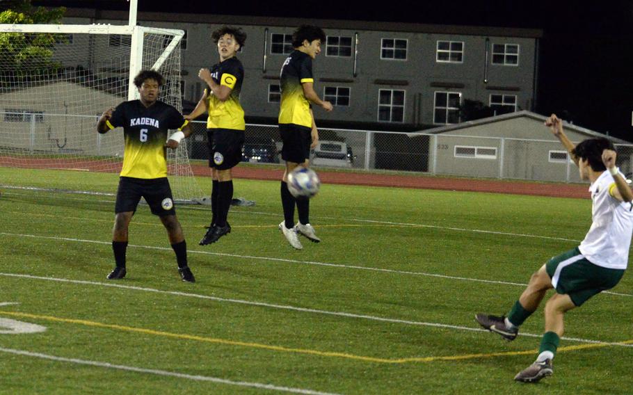 Kubasaki's Frank Stare lets fly a free kick over Kadena defenders Derek Vaden, Nolan Taylor and Noa Barrett during Wednesday's Okinawa boys soccer match. Stare scored his 10th goal of the season in a losing cause as the Panthers edged the Dragons 3-2.