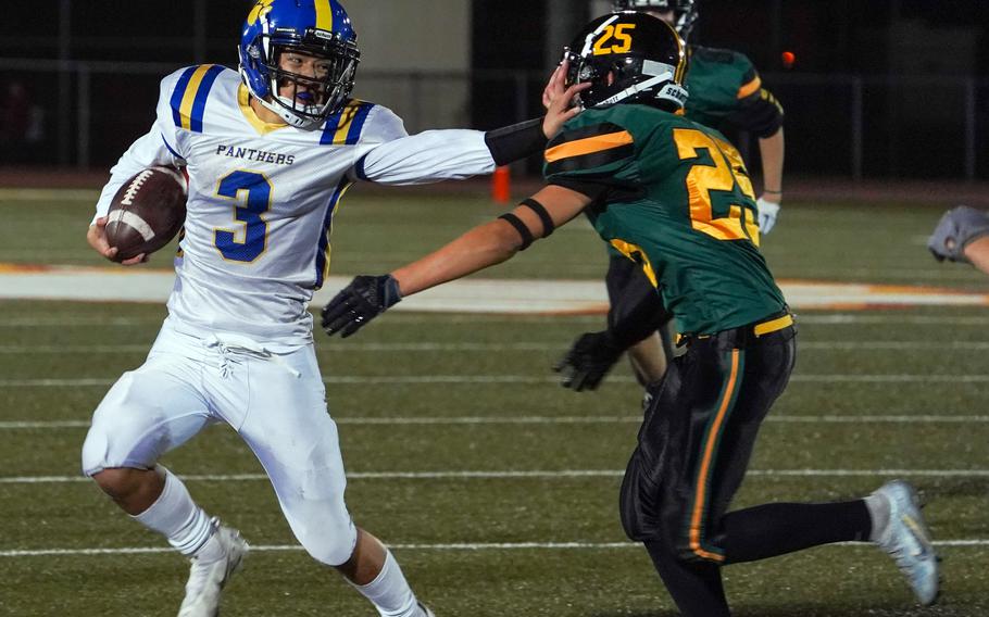 Yokota quarterback Dylan Tomas stiff-arms Edgren's Santiago Castano as he carries the ball.