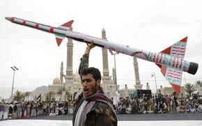 A Houthi supporter raises a mock rocket during a rally against the U.S. and Israel and to support Palestinians in the Gaza Strip, in Sanaa, Yemen, Friday, April. 26, 2024. (AP Photo/Osamah Abdulrahman)