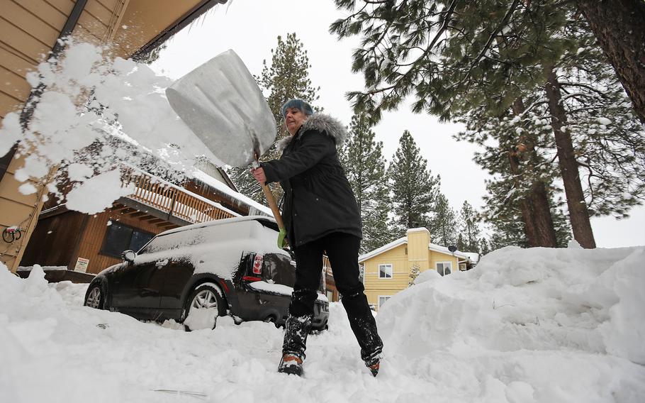 Amblerlee Barden shovels snow after successive storms dumped several feet of snow blocking her driveway on Tuesday, Feb. 28, 2023, in Big Bear Lake, Calif.