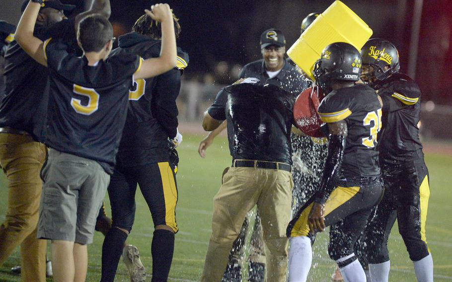 Kadena coach Sergio Mendoza gets the water-bucket treatment while players and spectators celebrate the Panthers' victory.