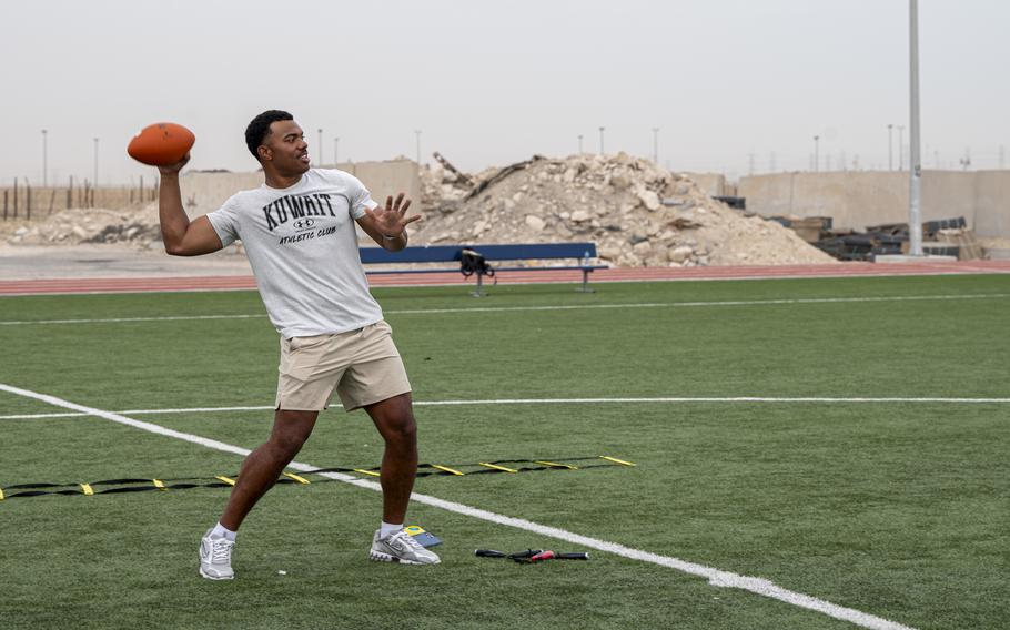 Elijah Higgins prepares to throw a football on a field