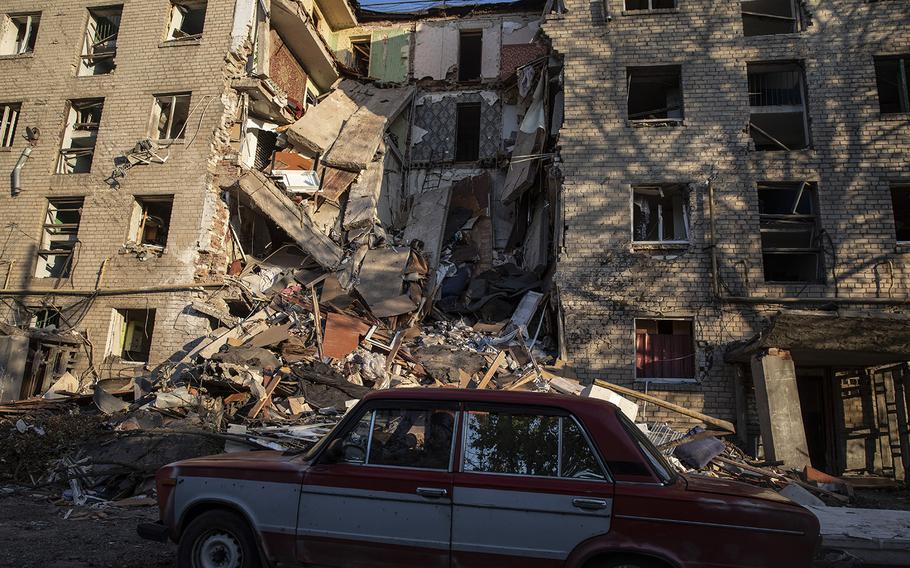 A resident arrives at a badly damaged building after it was hit by a Russian rocket strike in Bakhmut. 