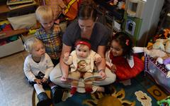 Malissa Kaye, 2017 Little Rock Air Force Base Family Child Care Provider of the Year, reads a book to her home day-care children Nov. 30, 2017, at Little Rock AFB, Ark. The Air Force is planning to construct four new child care centers across the nation