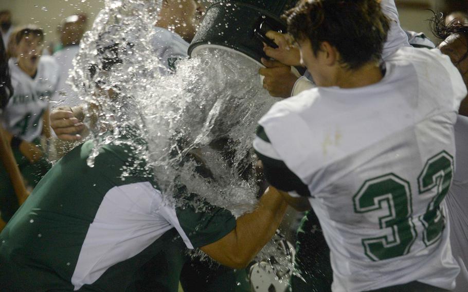 Kubasaki coach Tony Alvarado gets the water-bucket celebration treatment from his Dragons players.