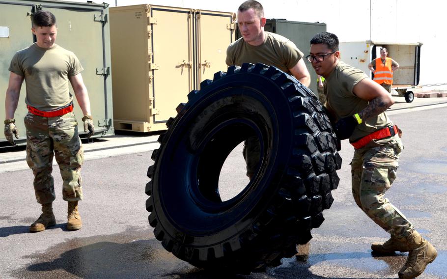 Staff Sgt. Matthew Rothrock and Senior Airman Gerald Dinio (right) flip a tire during the endurance event at the 721st Aerial Port Squadron Multi-Capable Airmen Rodeo at Ramstein Air Base, July 23, 2021. The tire the pair from Spangdahlem Air Base had to move was filled with water.