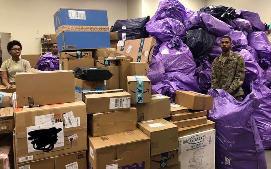 Airmen pose with packages inside the post office at Yokota Air Base, Japan, in December 2019. 