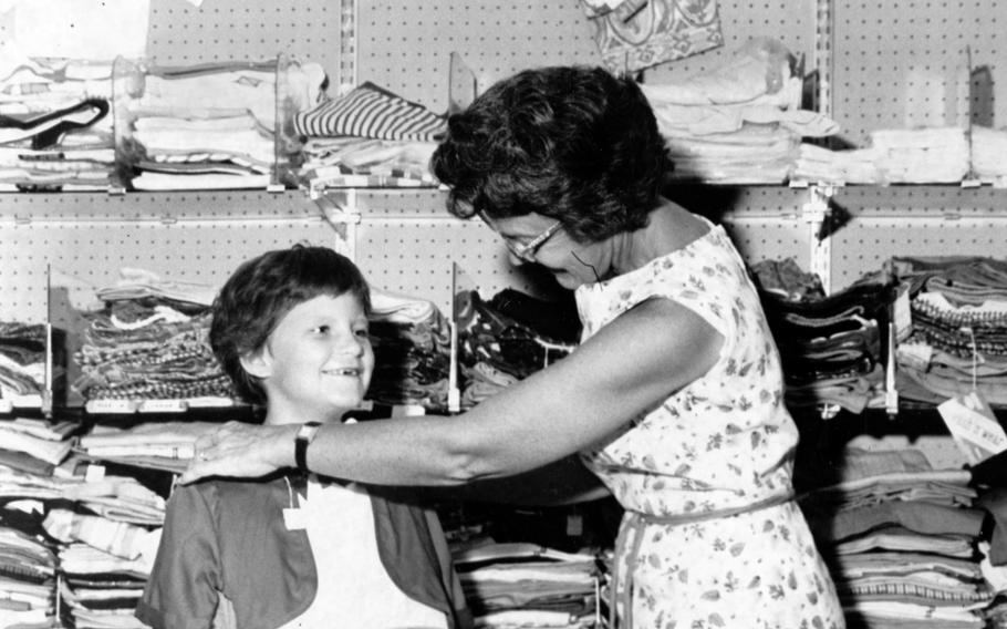 Youngsters stock up with school supplies and back-to-school clothes at the Naha Air Base Exchange as they prepare for the opening of U.S. dependent schools on Okinawa. Stacey Somppi’s mom makes sure she has a proper fit for her new back-to-school dress on Aug. 25, 1962.