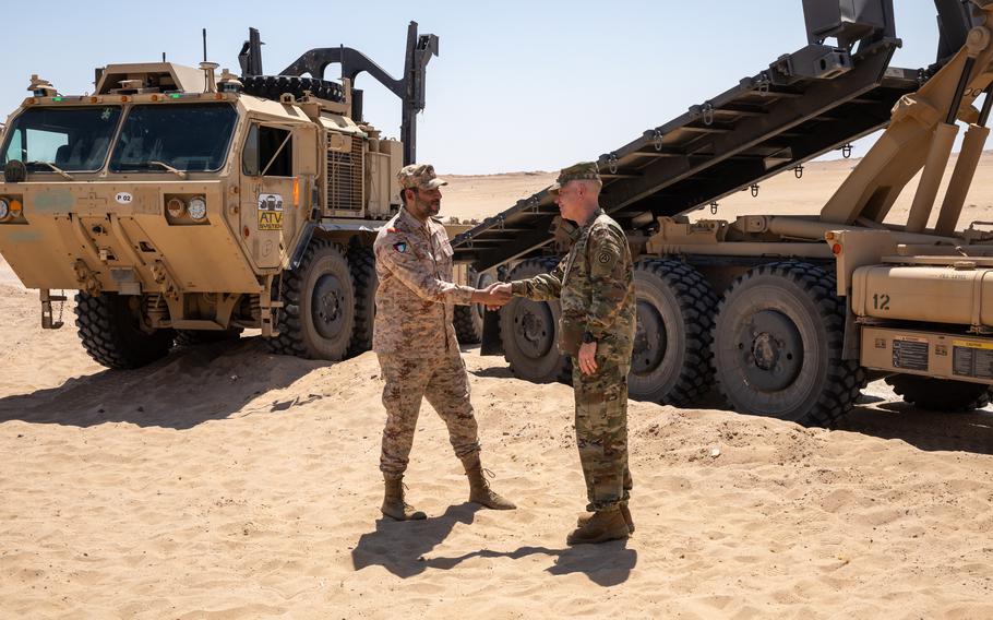 Lt. Gen. Patrick Frank, commanding general of U.S. Army Central, shakes hands with Kuwait's Col. Fahad Buresli at Camp Buerhing, Kuwait, on July 25, 2023. The 371st Sustainment Brigade was testing driverless trucks there.