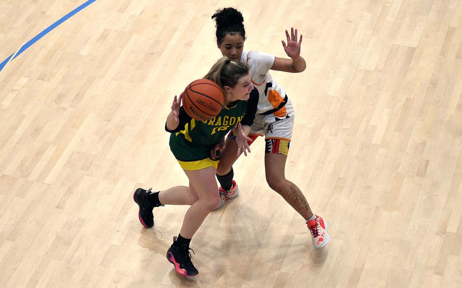 Alconbury senior Paige Sander drives the baseline against Spangdahlem junior Caleya Morton during pool-play action of the DODEA European basketball championships on Feb. 14, 2024, at the Wiesbaden Sports and Fitness Center on Clay Kaserne in Wiesbaden, Germany.