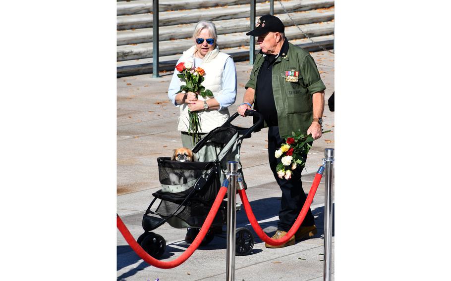 Visitors and their dog approach the Tomb of the Unknown Soldier on Wednesday, Nov. 10, 2021. Thousands of people placed flowers at the tomb during a two-day ceremony. 