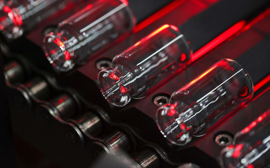 Glass vials move along a conveyor at the Gerresheimer medical glassware factory in Buende, Germany, on Aug. 11, 2020.