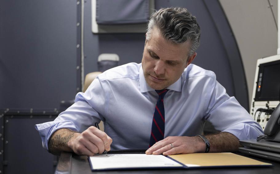 Pete Hegseth signs a memo about an E-4B Nightwatch aircraft.