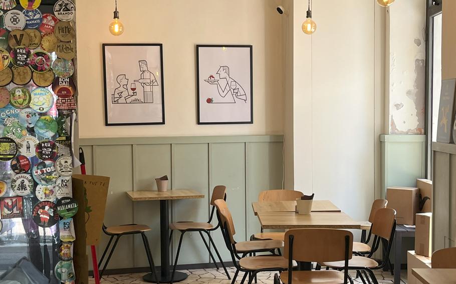 Inside Bacaro della Pizza restaurant, with tables, chairs and drawings on the wall.