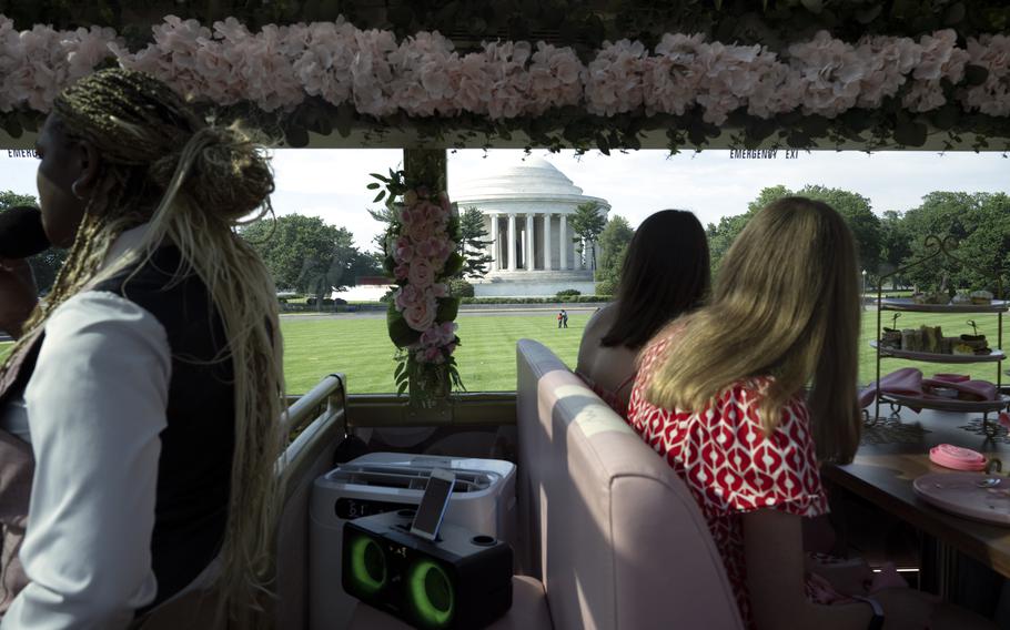 People look out a tour bus window at the Jefferson Memorial in Washington.