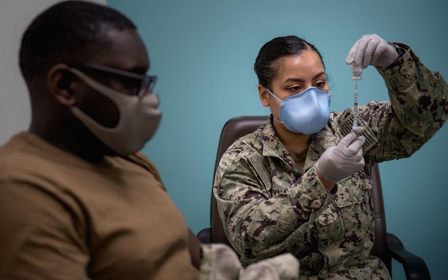 Hospital Corpsman 2nd Class Amanda Reyna, right, prepares to administer a coronavirus vaccine to Information Systems Technician 2nd Class Issac Patrick at Naval Support Activity Bahrain on March 30, 2021. 