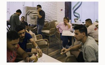 Mona Adnan Al-Ghalayini, 55, a businesswoman from Gaza, works with employees to prepare her new restaurant for its opening in Cairo. 