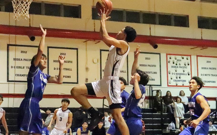 Zama's Jarius Brown drives for a shot against Christian Academy Japan defenders during Monday's Kanto Plain boys basketball game. The Trojans won 57-33.